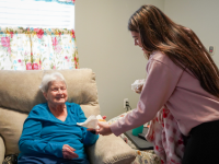  Senior Citizen receiving a cookie from a Bears Who Cares member